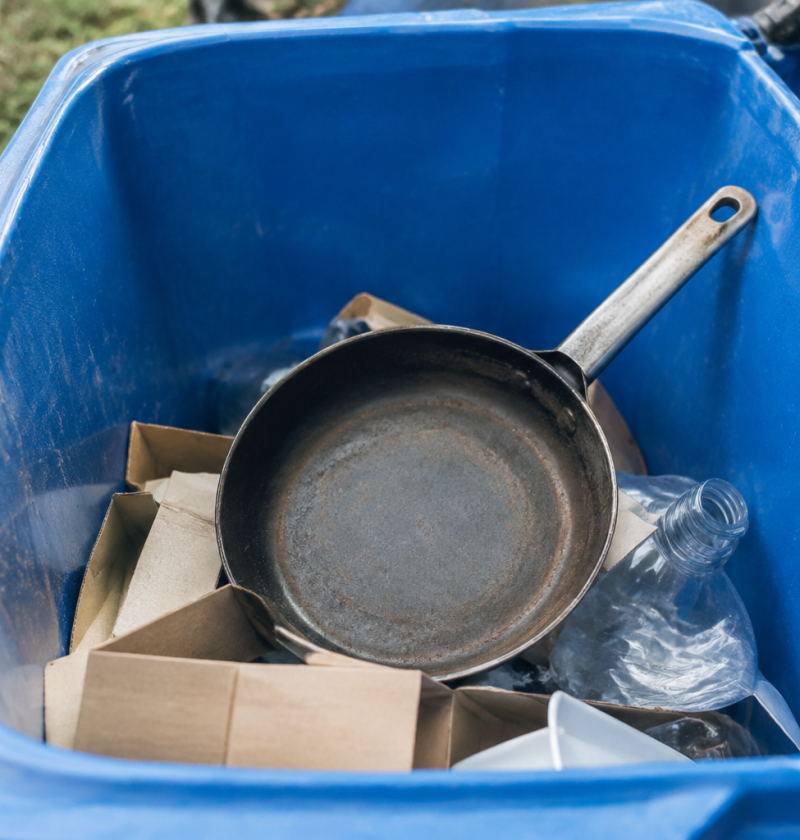 Poele metallique deposee dans un bac de recyclage